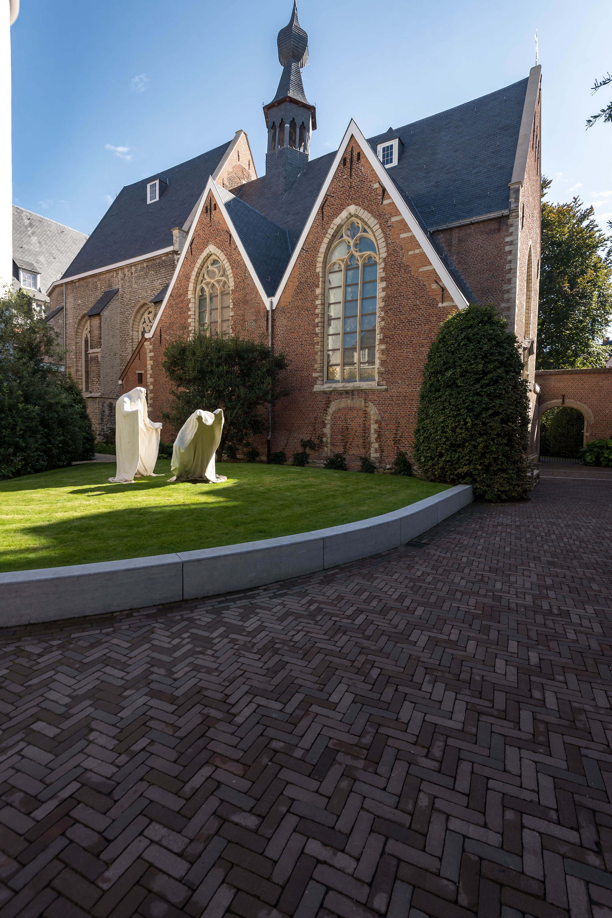 De gotische kapel van Botanic Sanctuary Antwerp, met haar spitsboogramen en torentje boven het grasplein.